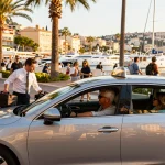 Taxis à St Tropez offrant une expérience de transport haut de gamme avec un véhicule de luxe devant la pittoresque Côte d'Azur.