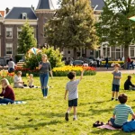 Engaging family outing tips den haag with kids enjoying a sunny picnic in a park.